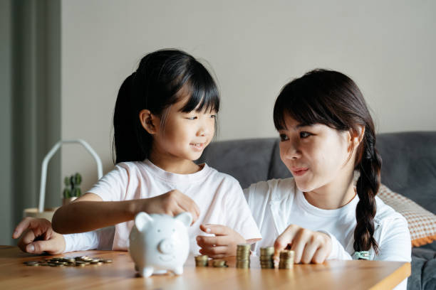 istock Young Asian girl learning about saving money 2180418196