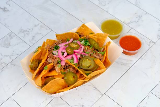 istock Mexican beef tacos with jalapenos, parsley, and fresh lime on ceramic surface 2180422040