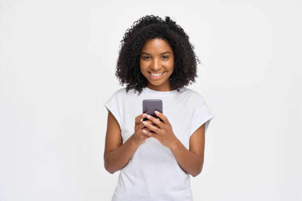 istock Young happy African woman standing isolated on white background using phone. 2180423064