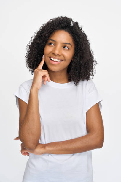 istock Curious young African woman looking away standing isolated on white background. 2180423079
