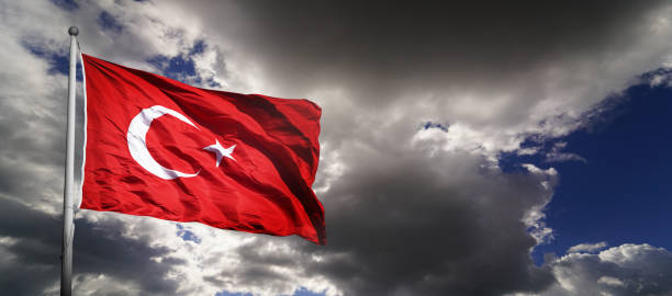 istock The Turkish flag waving among dark clouds. 2180429171