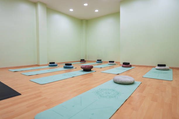 Step into a serene yoga studio with mats and pillows for a peaceful class, bathed in gentle light for meditation and relaxation. Embark on a journey of wellness and balance in this inviting space