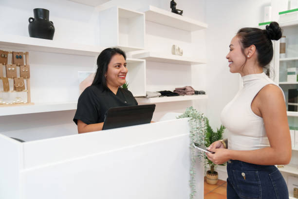 istock Beautician smiling at customer at clinic reception desk 2180429845
