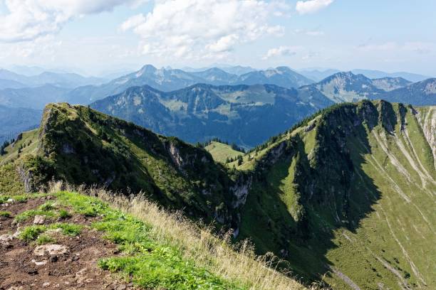 istock Panoramic view of lush green mountains under a partly cloudy sky. 2180433554