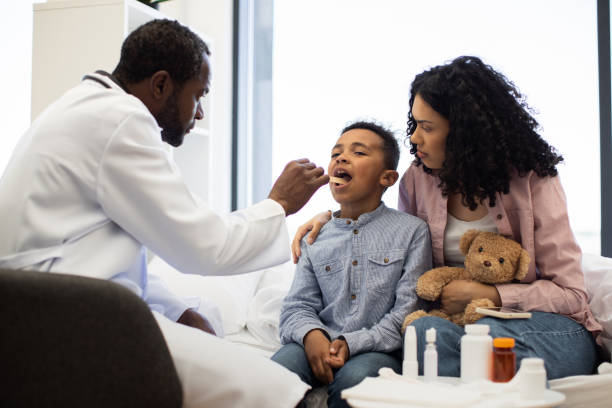 istock Doctor examining sick boy with mother holding teddy bear 2180439948