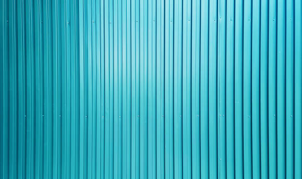 real chrome light blue corrugated metal sheet wall showing vertical pattern, bolts, screw. modern industrial grey metal sheet wall facade. real chrome light blue corrugated metal sheet wall showing vertical pattern, bolts, screw. modern industrial grey metal sheet wall facade. wide surface of cyan aluminum wall texture use for design. corrugated metal fence ideas stock pictures, royalty-free photos & images