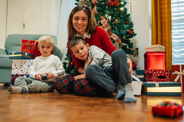 istock Happy family celebrating christmas posing by a decorated tree 2180441659
