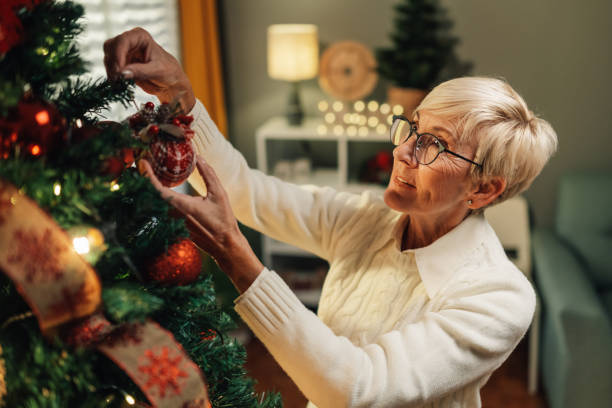 istock Senior woman decorating christmas tree at home 2180441712