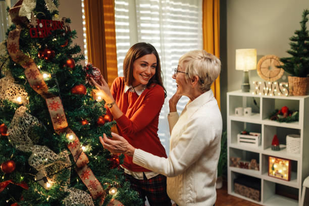 istock Happy women decorating christmas tree at home 2180441714