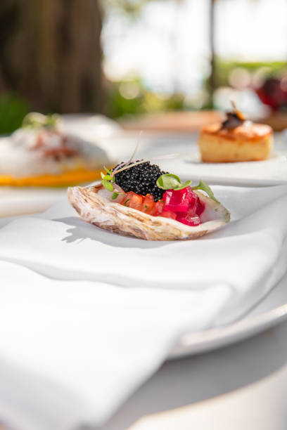 istock Michelin Fine dining restaurant Appetizers tasting menu at elegant gourmet table plates with puff pastries, caviar oyster, herb leaves and flavour gels 2180442504