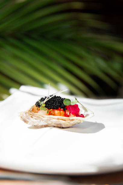 istock Michelin Fine dining restaurant Appetizer tasting menu at elegant gourmet table plate with caviar oyster and palm leaf 2180443009
