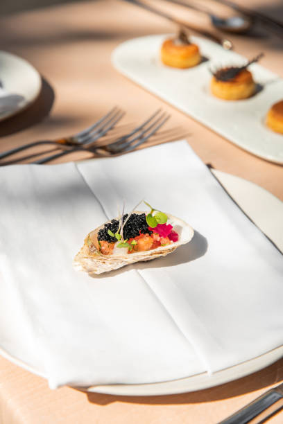istock Michelin Fine dining restaurant Appetizers tasting menu at elegant gourmet table plates with puff pastries, caviar oyster, herb leaves and flavour gels 2180443179