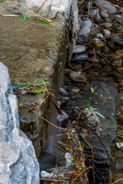 A stream tumbles down the mountainous hillside across rustic rock