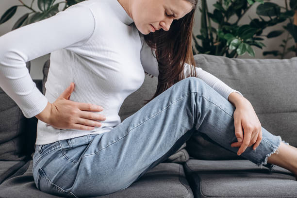 istock Upset unhappy young woman frustrated by problem with relationships, sitting on sofa, embracing knees, covered face in hand, feeling despair and anxiety, loneliness, having psychological trouble 2180446096