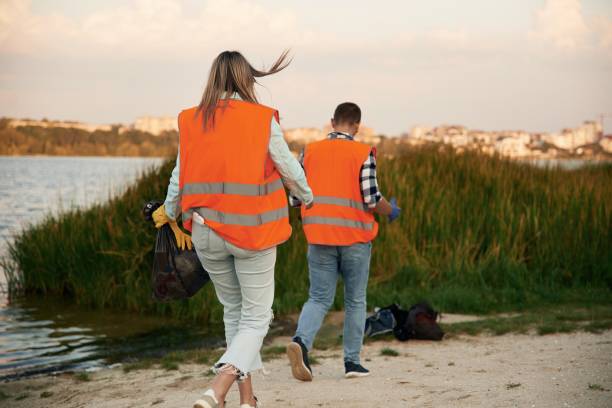 istock A volunteers collects garbage on a muddy beach 2180450556