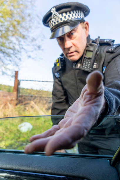Male security officer putting his hands up as a stop sign on camera, showing a limitation symbol against blue background. Serious patrol agent restricting the access, does a rejection gesture.