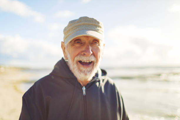 Friendly old man enjoys the sun at the Baltic Sea.
