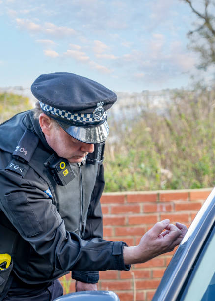 istock UK police officer approaching a parked car 2180451448