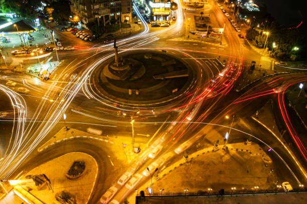 istock Traffic at an urban roundabout at night 2180454904