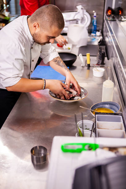 istock Chef seasoning seafood in restaurant kitchen 2180456187