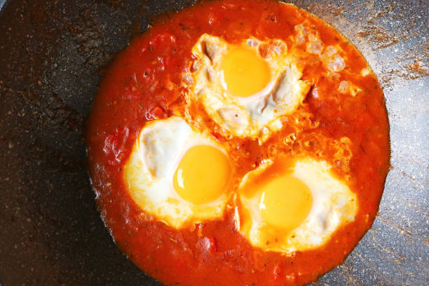 istock Eggs being poached in spiced tomato sauce for Shakshuka Dish 2180456898