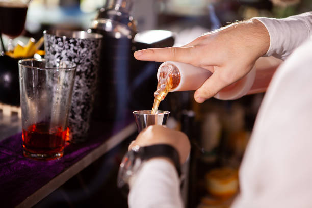 istock Barman in white shirt pouring drink incredient 2180456915