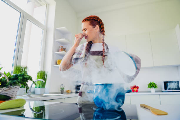 Photo of lovely cute girl housewife cooking lunch dinner avoid disgusted smell soup kitchen room home house indoors Photo of lovely cute girl housewife cooking lunch dinner avoid disgusted smell soup kitchen room home house indoors. terrible meal stock pictures, royalty-free photos & images