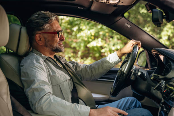 istock Side view of senior man that is driving a car 2180457468