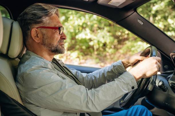 istock Side view of senior man that is driving a car 2180457502