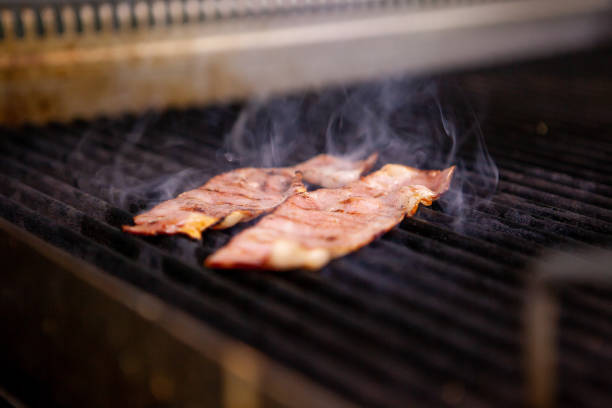 istock Delicious smoked bacon on grill in kitchen restaurant 2180458289