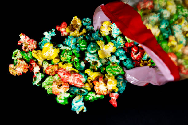 istock Fallen package with colorful popcorn scattered on black background 2180459120