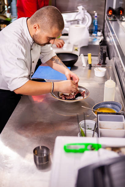 istock Chef seasoning seafood in restaurant kitchen 2180459287