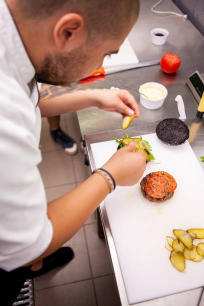 istock Chef puts pickles on delicious burger meat 2180459769