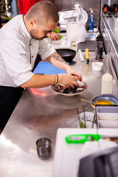 istock Chef seasoning seafood in restaurant kitchen 2180460059