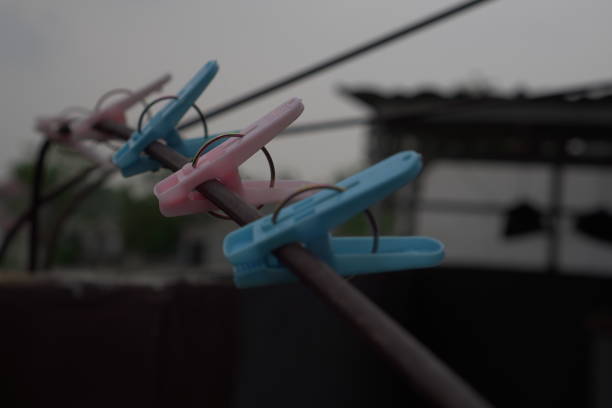 Red, yellow and wooden clothespins on a clothesline on a sunny day, low angle view.
