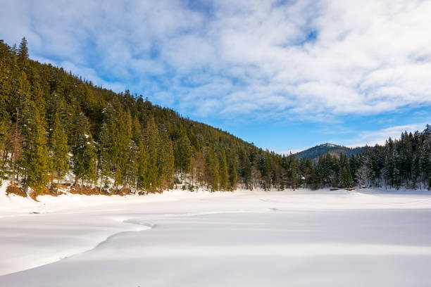 istock snow covered mountain lake among the forest at forenoon 2180462300