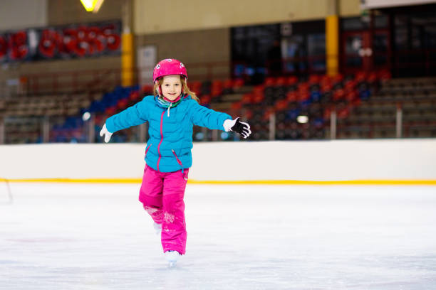 istock Child skating on indoor ice rink. Kids skate. 2180462421