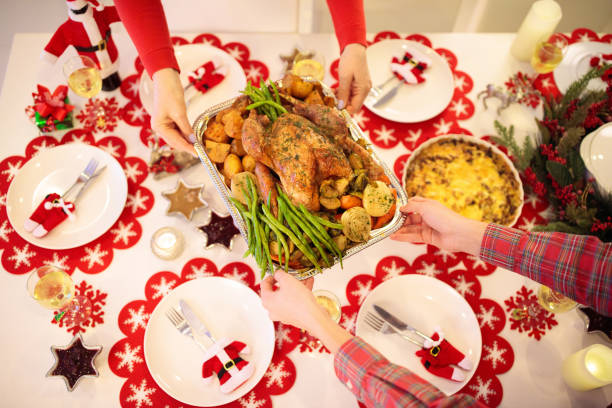 istock Family with kids having Christmas dinner at tree 2180462929