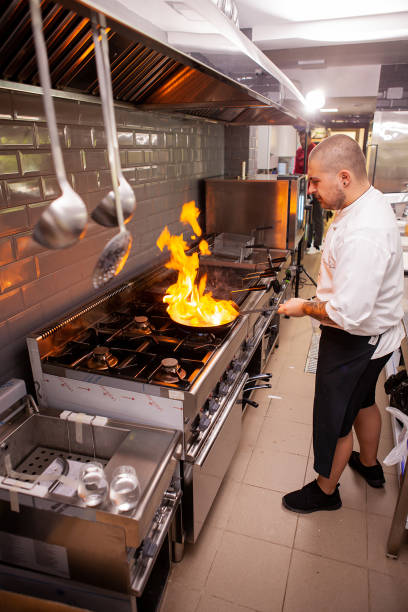 istock The chef prepares the dish on the stove with an open fire 2180467966