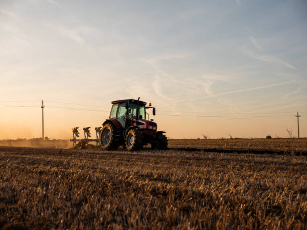 istock Tractor plowing and preparing stubble field for crop seeding 2180468486