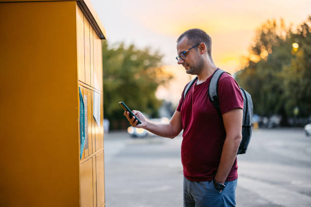 istock Mid-Adult Man Picking Up His Package From An Electronic Parcel Locker Using His Phone 2180469610