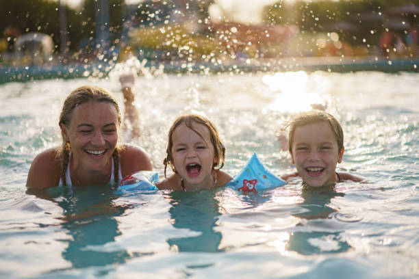 istock Happy family splashing in the pool 2180469710