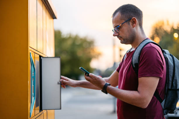 istock Mid-Adult Man Picking Up His Package From An Electronic Parcel Locker Using His Phone 2180469839