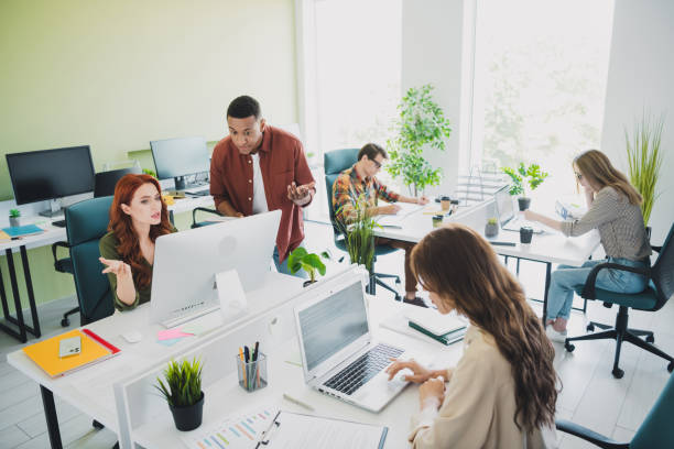 istock Photo of group five young corporate workers computer desktop conversation workstation office business center indoors 2180470854