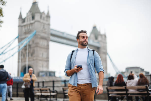 istock Man Exploring Tower Bridge in London Holding Smartphone 2180472551