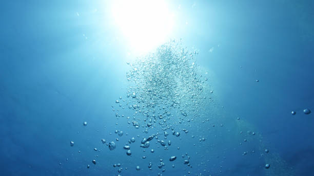 istock Rays of light and air bubbles below the blue ocean surface 2180473287
