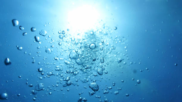 istock Rays of light and air bubbles below the blue ocean surface 2180473290