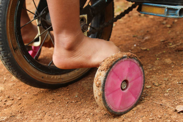 barefoot boy riding bike on outdoor ground