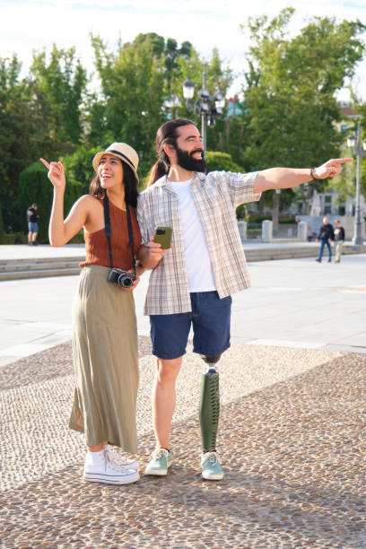 istock Happy tourist couple with prosthetic leg using smartphone gps for directions 2180475646