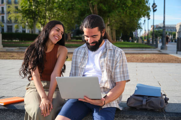 istock Students smiling and looking at laptop in the city 2180476716